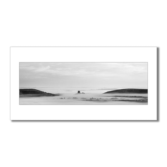 Dramatic black and white art print capturing Corfe Castle in Dorset rising majestically from a surreal cloud inversion
