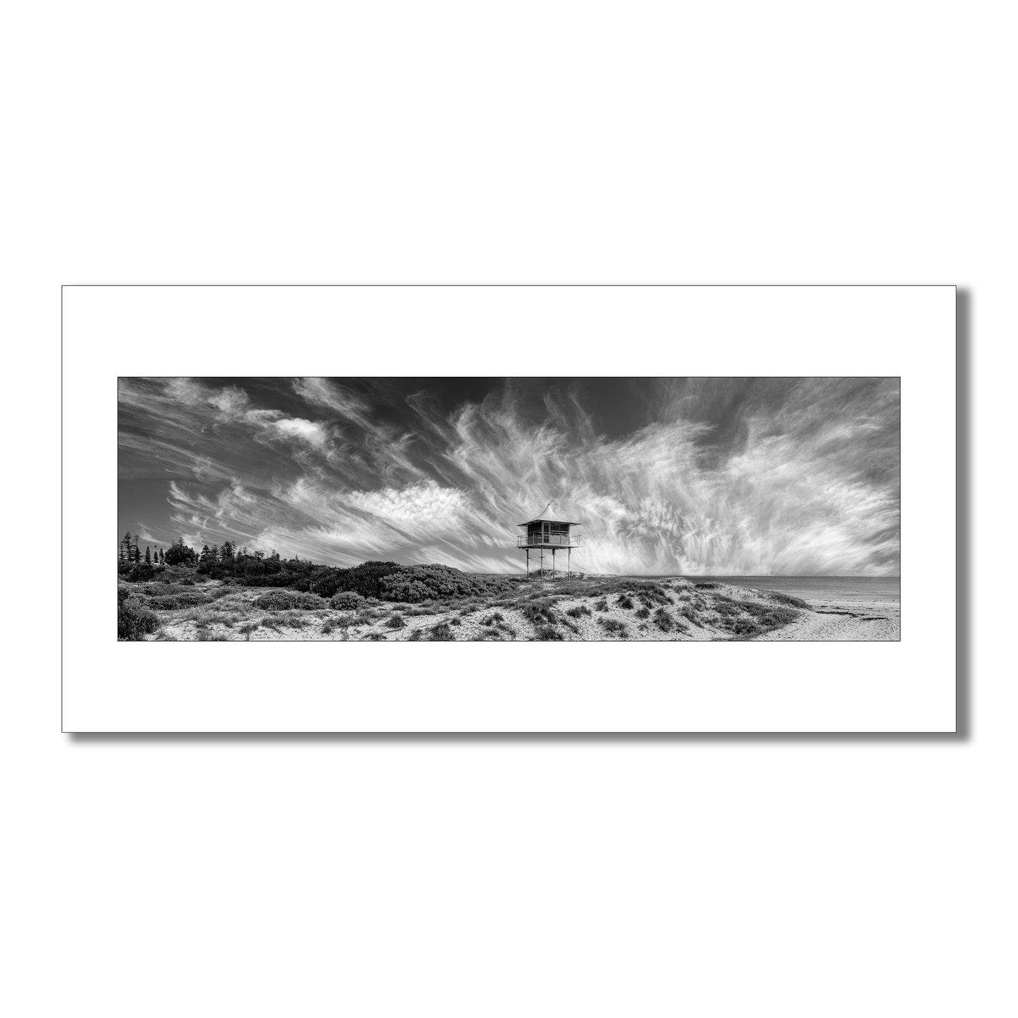 Escape to the coast with this breathtaking black and white panorama  art print of Semaphore Beach, Australia. Featuring a historic lookout tower and awe-inspiring clouds, this limited-edition print is a must-have for any art lover or traveller