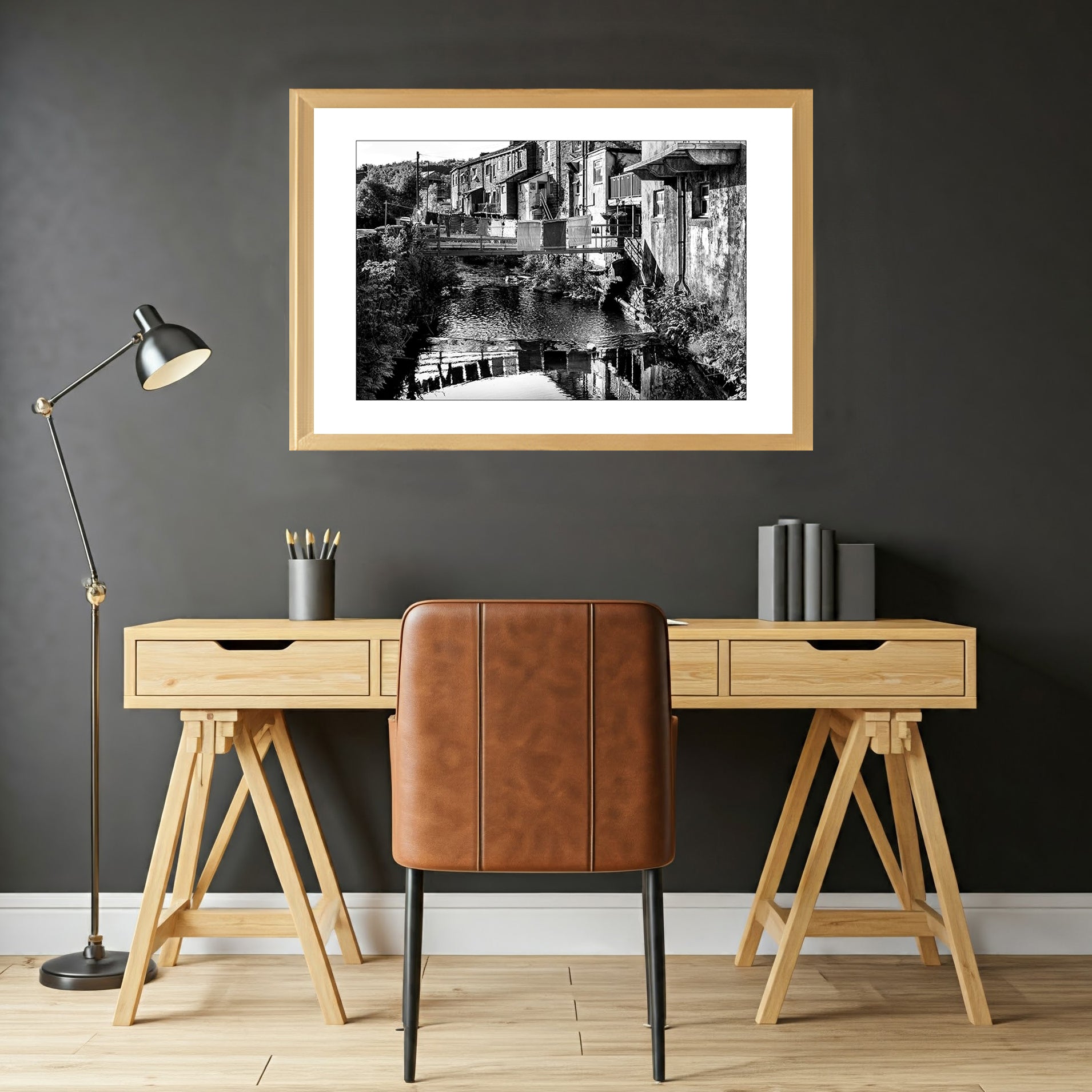This evocative black and white wall art print transports you to a simpler time. Laundry drying on a clothesline, a rustic bridge, and charming cottages create a scene of peaceful village life